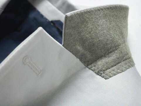 Close-up of a stylish grey jacket collar with detailed stitching and felt liner.