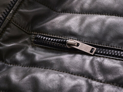 Close-up of a black leather jacket with a metallic zipper detail.