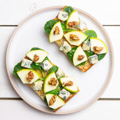 Bruschetta with spinach, honey, blue cheese, pear, and nuts. Healthy eating. Vegetarian food.