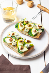 Bruschetta with spinach, honey, blue cheese, pear, and nuts. Healthy eating. Vegetarian food.