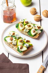 Bruschetta with spinach, honey, blue cheese, pear, and nuts. Healthy eating. Vegetarian food.