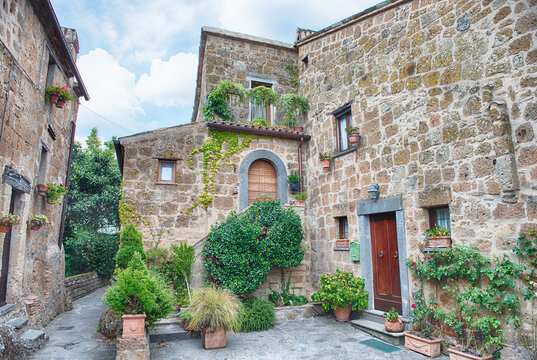 Ancient Stone Dwellings and Verdant Foliage in Civita di Bagnoregio - Powered by Adobe