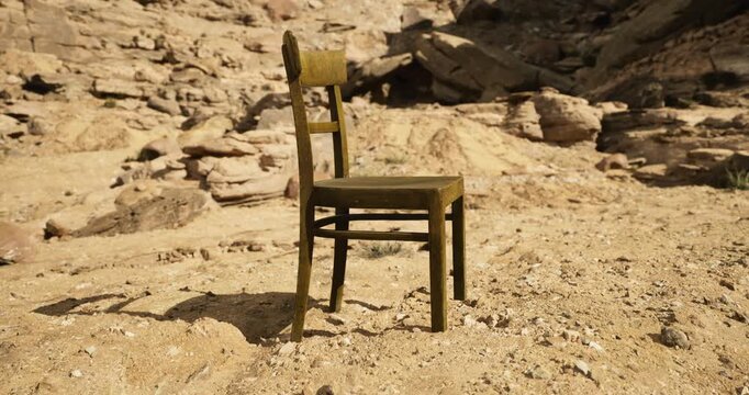 In a desolate location, a solitary wooden chair casts a shadow on dry ground, surrounded by rocky formations. The bright sunlight highlights its weathered texture and color.
