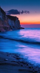 Fototapeta premium Coastal cliff with bioluminescent waves at sunset