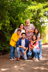 Fototapeta premium Indian family bonding happily while standing outdoors and smiling together