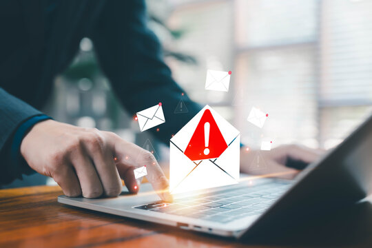 Business person receiving a digital email warning alert on a laptop, symbolizing cybersecurity risks, phishing threats, data protection, system notifications, and online communication issues in modern