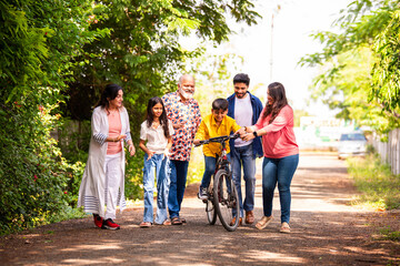 Indian kid learning bicycle with family support and joyful outdoor bonding