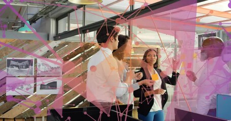 Lead man placing post-its on glass, team arranging plan for project, pink overlay obscuring parts