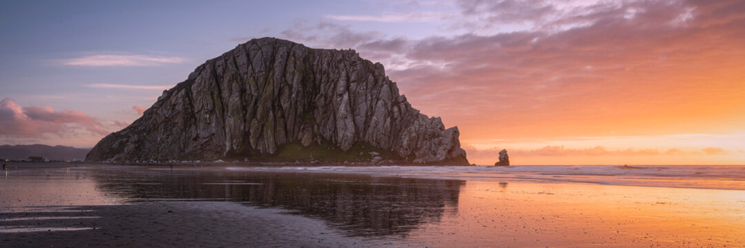 Coastal Monolith Reflected on a Calm Shore at Sunset