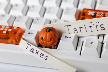 white and orange keycaps, next to "taxes" and "tariffs" labels. economic policy and halloween.
