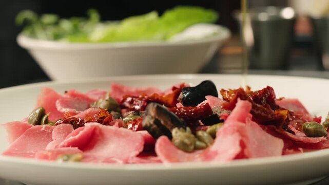 Delicious Spanish or italian ham served as rolls with green olives on white plate, chef cooking buffet menu. 