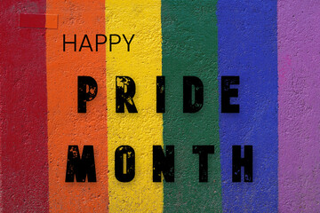 Happy Pride Month. Letters painted on a wall in the colors of the rainbow flag.