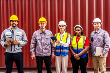 Portrait of group male and female container worker or dock foreman confident and smiling standing at warehouse logistic in Cargo freight ship for import export in harbor, happy employees arms crossed