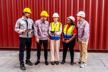 Happy diverse group of engineers workers checking inventory with tablet device in the container yard background. This is a freight transportation and distribution warehouse.