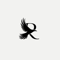 Obraz premium Stylized black bird with outstretched wings flying gracefully next to a bold capital letter R on a clean white background, elegant graphic design.