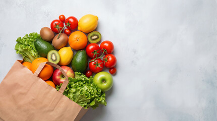 Top view of a paper bag overflowing with fresh vegetables and fruits on a background with copy space