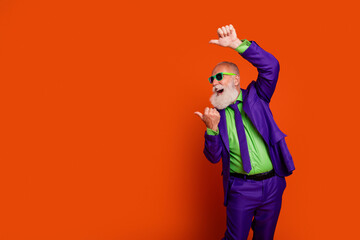 Energetic elderly man in a bright purple suit dances with joy against a bold orange background for vibrant fashion lifestyle ads