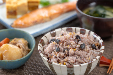 雑穀米と焼き鮭が並ぶ和食の朝ごはんと家庭的な食卓