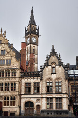 Close-up view of ornate medieval fa&ccedil;ades and a clock tower in the historic city center of Ghent, Belgium, showcasing gothic architectural elements and rich European heritage.