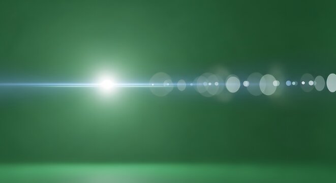 Bright light with lens flare effect on a green background creating a bokeh effect and a light streak