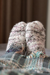 Soft knits atop cozy blanket, Gentle morning ambiance featuring plush socks and quilted blanket in subdued colors
