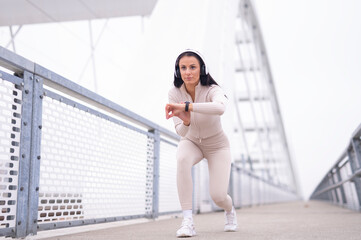 Woman exercising on bridge checking smartwatch