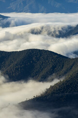 Valley fog covering mountain peaks at sunrise