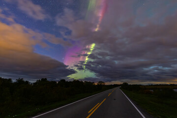 The stunning Northern Lights over Lofoten Islands, Norway, with vivid colors lighting up the night sky above mountains.