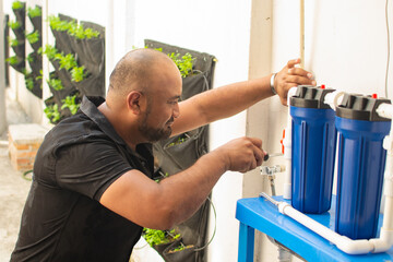 Man maintaining urban home outdoor water filtration system