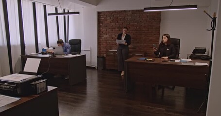 Business associates collaborate in a modern office, discussing work and using technology. Teamwork, communication, and professionalism are evident in this corporate setting.