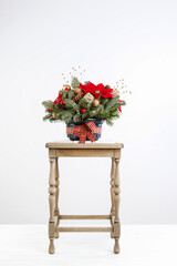 Christmas decoration with the poinsettia flower (Euphorbia pulcherrima), fir, baubles and cones.