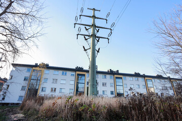 KRAKOW, POLAND - NOVEMBER 19, 2025: Power pole with electric wires very close to the facade of an apartment block.
