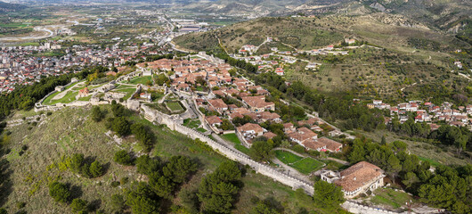 Aerial panorama of Berat Castle showcasing its walls, tiled-roof homes and the wider valley landscape stretching into the hills.