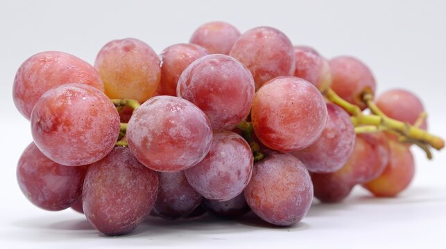 A close-up of a cluster of fresh, juicy red grapes set against a plain background, ideal for food-related content, health articles, or marketing materials focused on nutrition and wellness,