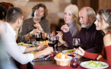 Multi-age group of people in restaurant. Organization of meetings, coffee breaks, and festive dinners.