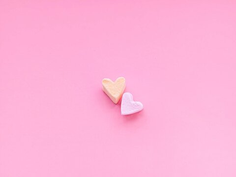  Soft pastel hearts on a clean pink background. Romantic and sweet composition ideal for Valentine’s Day creatives, social media content, greeting cards and festive promotions. - Powered by Adobe