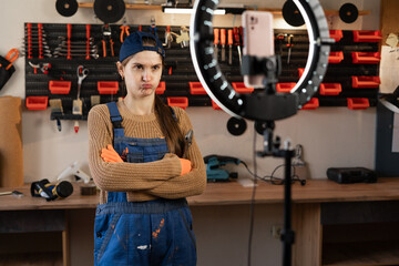 angry Repairman or Handyman blogger streaming in workshop with assortment tools use smartphone,...