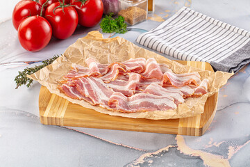 Sliced pork bacon over board
