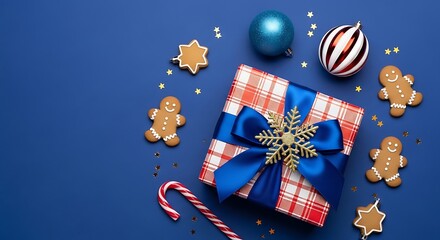 Festive christmas gift box surrounded by holiday treats and ornaments