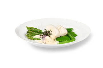 White fish fillet served with green vegetables and cream sauce on a white plate