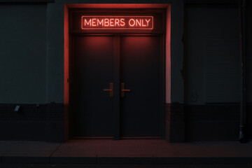Members only door with red neon. Private club entrance with glowing frame. Urban architecture exterior with dark wall.