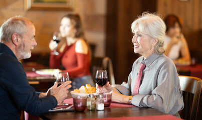 Mature couple communicate and chatting during date in cafe, have rendezvous, lovers tryst. Meeting on neutral territory, discussing personal and business issues