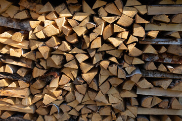 A pile of split dry wood on a clear sunny day