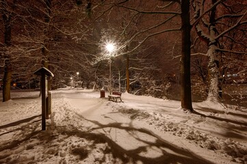 Sidewalk across the City Park in Pelhřimov 2025, sunken benches, street lighting, clean snow cover