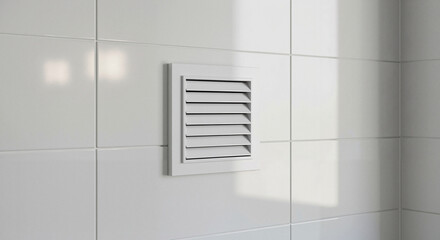 White vent cover mounted on bathroom tile wall with natural light  