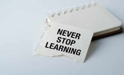 A piece of paper with the words Never Stop Learning written on it