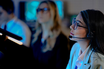 Command center lead focused intense monitoring critical systems late night headset connects team analyzing real time data screen crucial vigilance protects infrastructure operation underway now execut