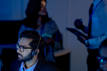 Command center lead focused intense monitoring critical systems late night headset connects team analyzing real time data screen crucial vigilance protects infrastructure operation underway now execut