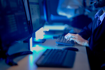 Close up male agent hands typing fast keyboard data entry customer support call center workflow efficiency modern tech hub blue light night shift achieve goals now communication key.