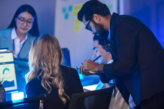 Security Operations Center, a dedicated diverse incident response team male and female in uniform analyzes live CCTV feeds on a video wall, strategizing their response to a critical security breach.